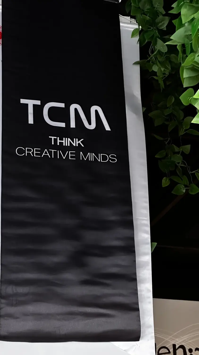 Siyah bez üzerinde TCM Think Creative Minds yazısı